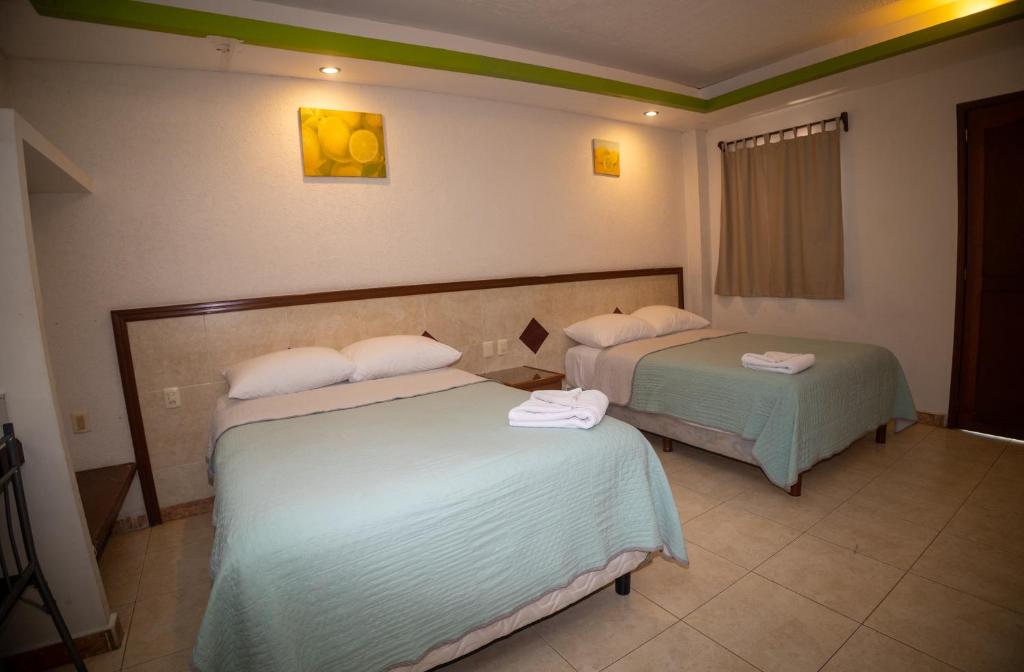 a hotel room with two beds in a room at Nicte Ha Campeche in Campeche