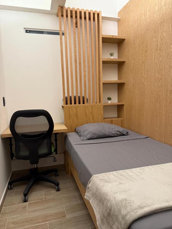 una habitación con dos camas y un escritorio y una silla en UCO Live Centro, en Ciudad de México