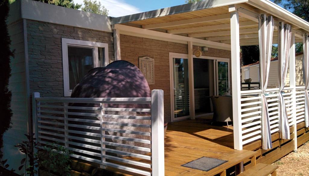 een huis met een veranda met een houten terras bij Mobile Homes Danijela in Amadria Park Trogir in Seget Vranjica