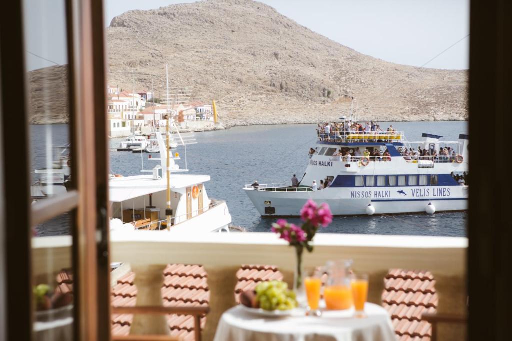 un restaurante con vistas a un barco en el agua en Villa Antonis, en Halki