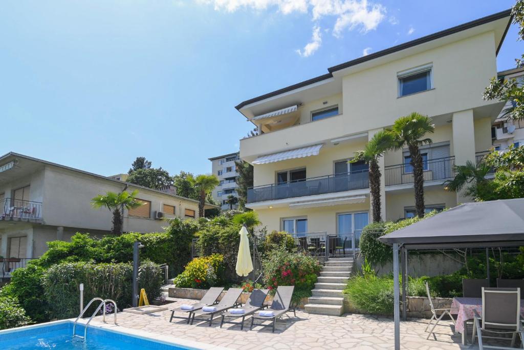 hotel z basenem i budynkiem w obiekcie Family-friendly apartments with swimming pools Opatija - 7916 w mieście Opatija