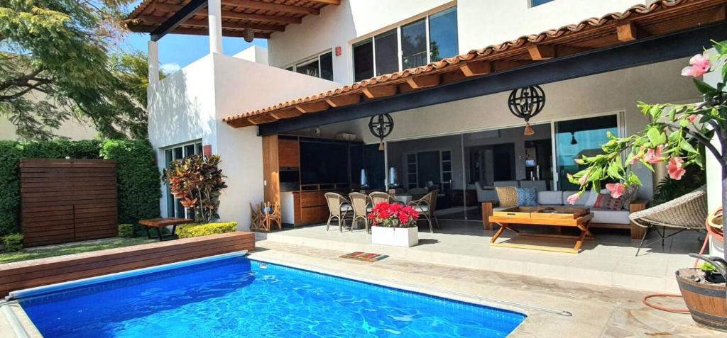 a house with a swimming pool in front of a house at Hermosa y exclusiva casa en La Reserva en Ajijic in Chapala