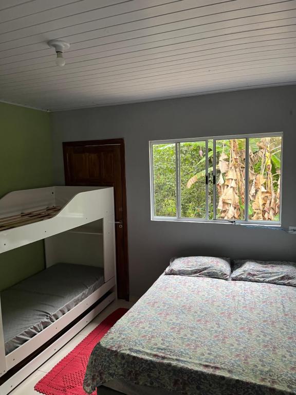 un dormitorio con una cama y una ventana en Casa da Jessica, en Paraty