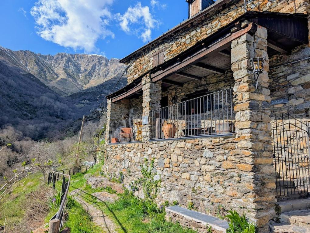 an old stone building with a dog in a window at Casa Rústica y Chic con Chimenea y Vistas Panorámicas de La Vall de Boí in Cardet