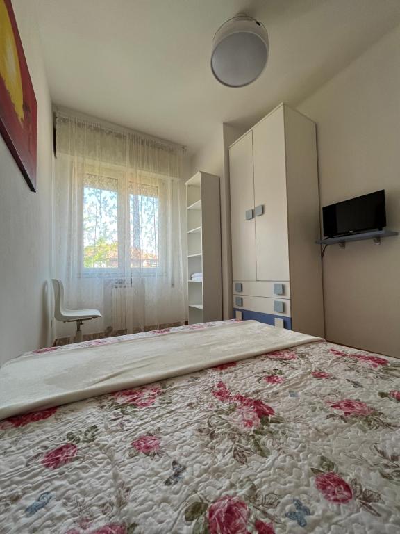 ein Schlafzimmer mit einem großen Bett mit Blumen darauf in der Unterkunft HOME FORNASINI - Fiera - in Bologna