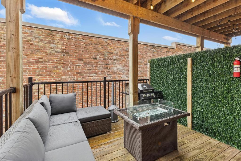 a patio with a couch and a brick wall at downtown Indy with Fire Pit and Free Parking in Indianapolis