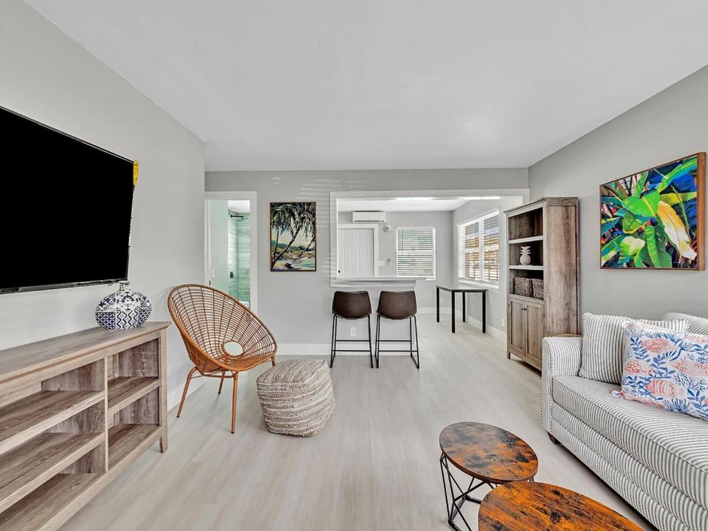 Una sala de estar con un sofá y un televisor de pantalla plana. en Beachside 1BR Apt - Walk to Hollywood Dania Beach, en Dania Beach