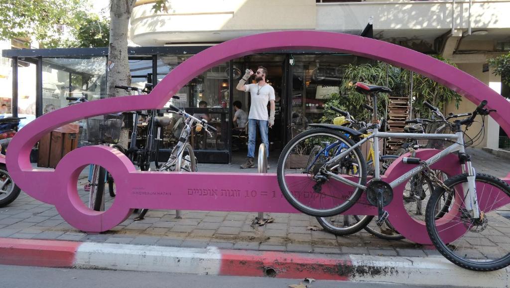 
a pink bicycle is parked in front of a pink wall at Florentin House in Tel Aviv
