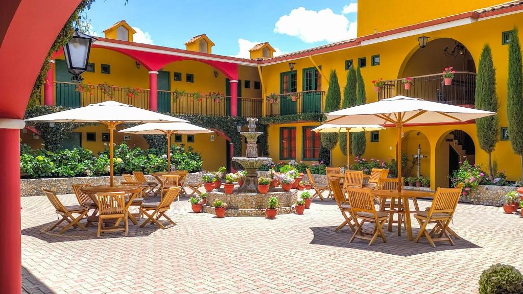 a courtyard with tables and chairs and umbrellas at Hotel Tartar in Cajamarca