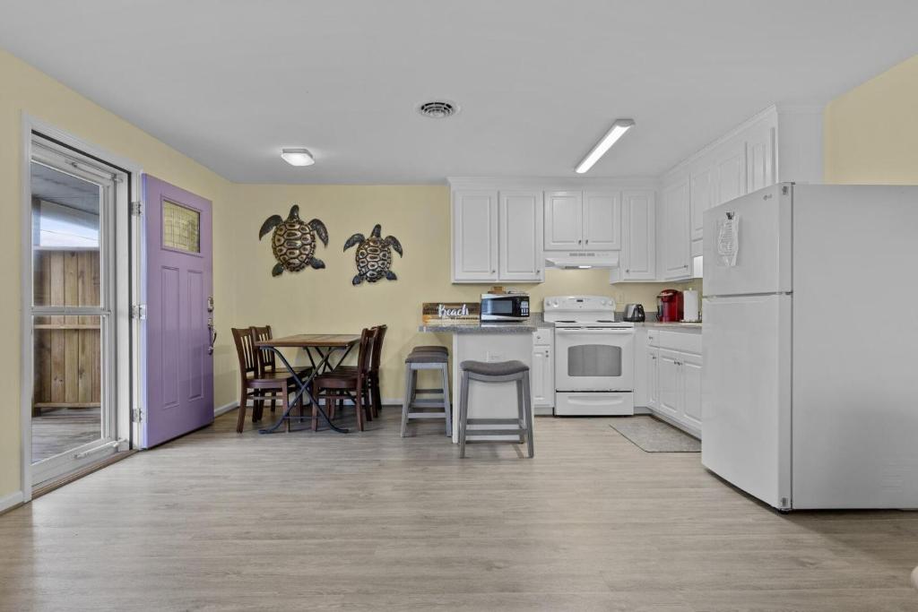 a kitchen with white appliances and a table and chairs at Boardwalk Shores C Duplex in Atlantic Beach