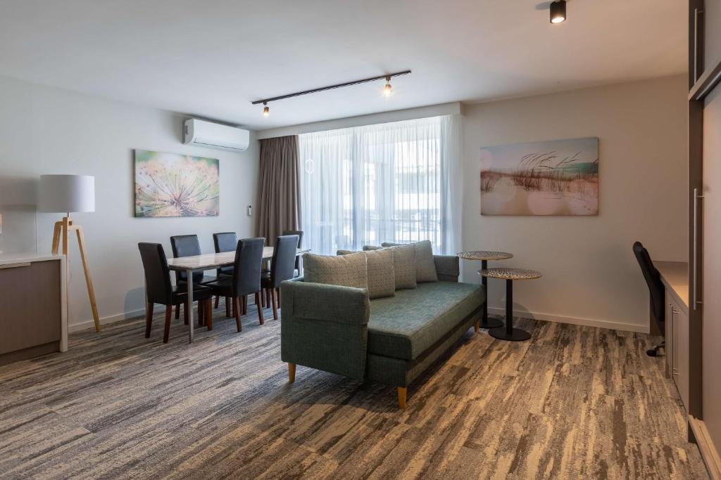 a living room with a couch and a table at Narrabeen Sands Hotel by Nightcap Plus in Narrabeen
