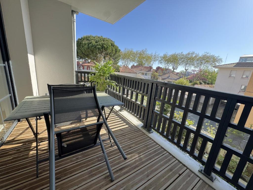 une chaise noire assise sur un balcon avec vue dans l'établissement Appartement à Arcachon avec terrasse, proche plage et parking - FR-1-474-268, à Arcachon