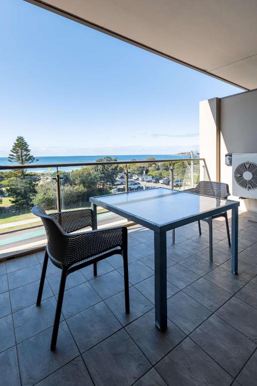 a ping pong table and chairs on a balcony at Narrabeen Sands Hotel by Nightcap Plus in Narrabeen