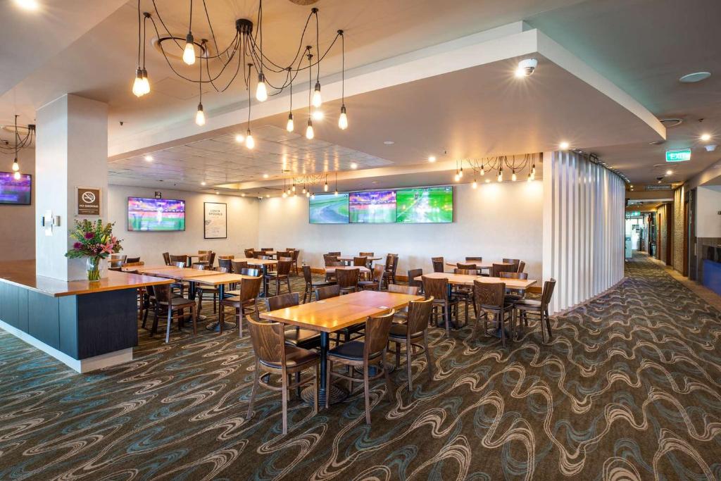 a dining room with tables and chairs in a restaurant at Narrabeen Sands Hotel by Nightcap Plus in Narrabeen