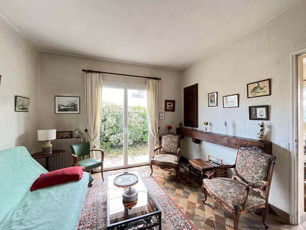 un salon avec un canapé bleu et des chaises dans l'établissement Arcachon : Maison 3 chambres idéale famille/amigos - FR-1-319-597, à Arcachon