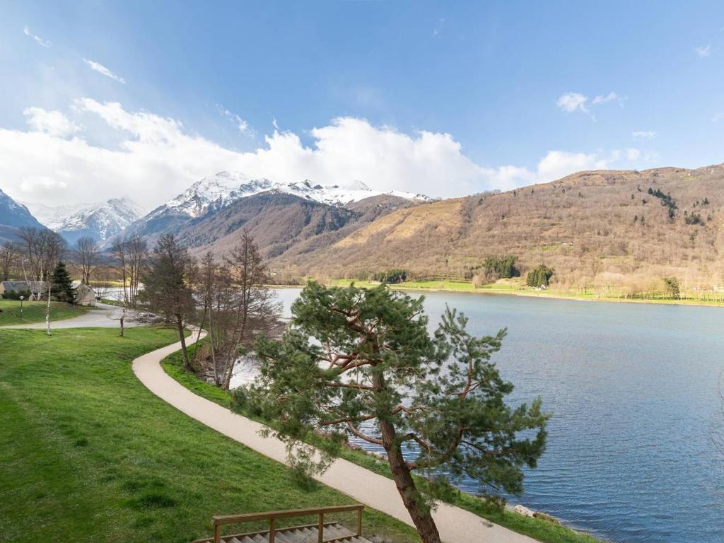 un parco con una panchina, un lago e delle montagne di Duplex rénové 6 pers avec vue sur lac à Loudenvielle - FR-1-695-72 a Loudenvielle