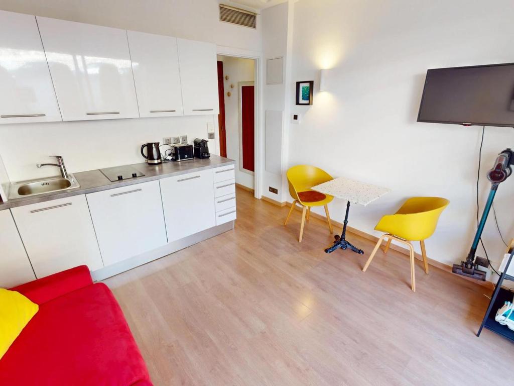 une cuisine avec des armoires blanches et des chaises jaunes dans une pièce dans l'établissement Studio climatisé avec terrasse et wifi proche plages à Menton - FR-1-196-377, à Menton
