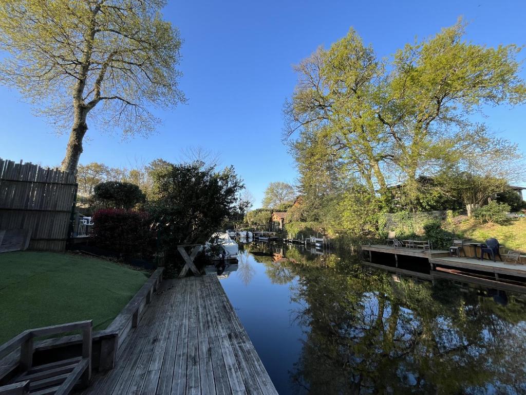 - une vue sur une rivière avec des arbres et un pont dans l'établissement Belle maison de 4 chambres au bord du canal à Cazaux - FR-1-319-598, à La Teste-de-Buch