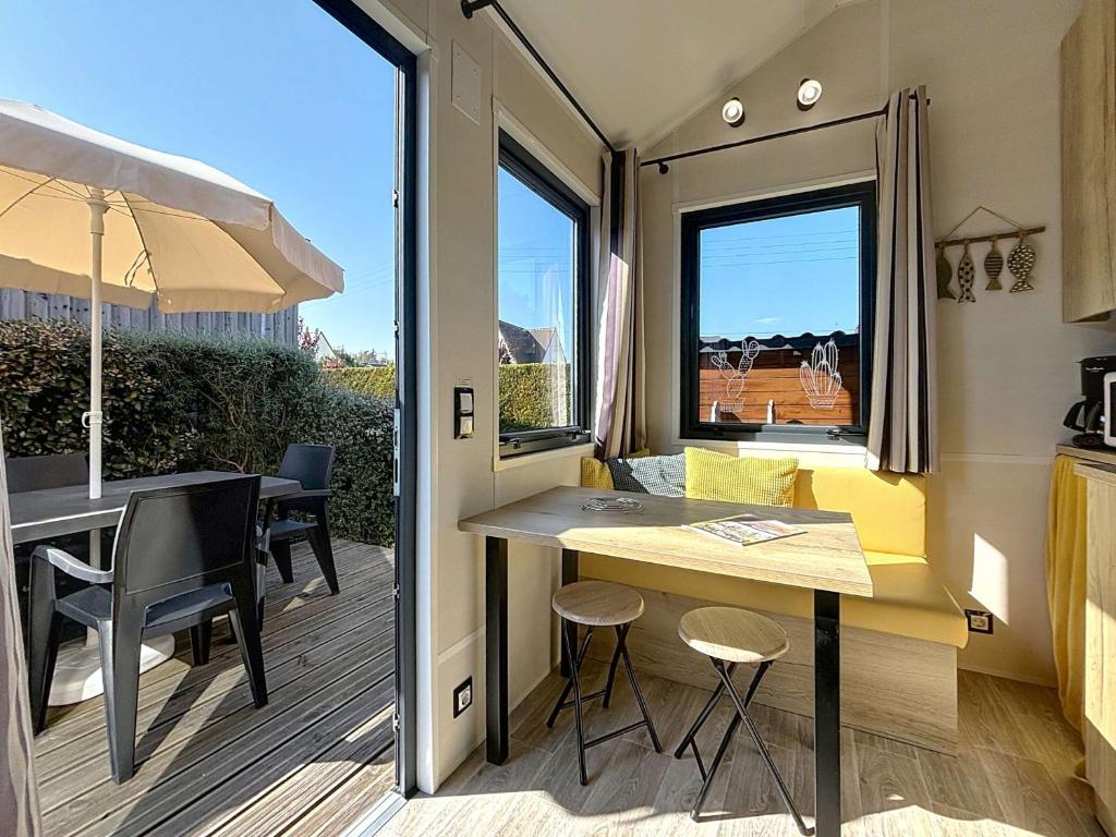 Tiny House 1 chambre, piscine chauffée, à 200 m de la plage, Jullouville - FR-1-361A-24 في جولوفيل ليه باه: مطبخ صغير ومنطقة لتناول الطعام مع طاولة وكراسي