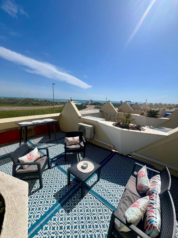 un patio avec des chaises et des tables sur un toit dans l'établissement Sea Chic - Naturist, au Cap d'Agde
