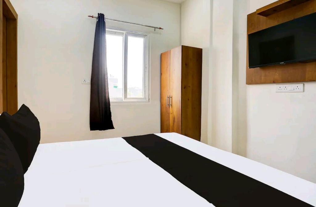 Un dormitorio con una cama en blanco y negro y una ventana. en Hotel Himalaya, en Kota