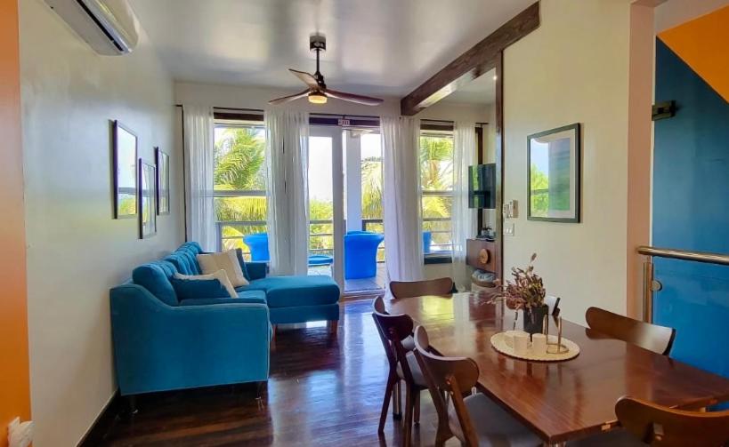 un soggiorno con un divano blu e un tavolo di 360 Suites Luxury Seaside Caye Caulker a Caye Caulker