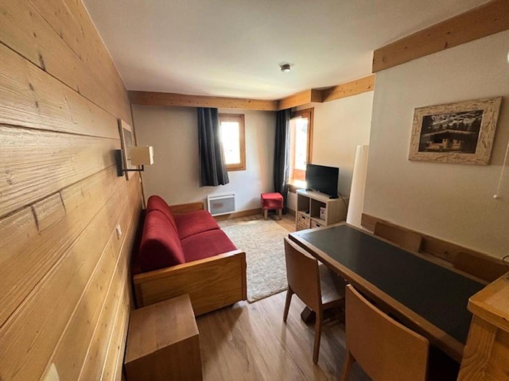 un salon avec un canapé rouge et une table dans l'établissement Résidence Aconit - maeva Home - 2 Pièces 4 Personnes Sélection MAE-8881, aux Menuires