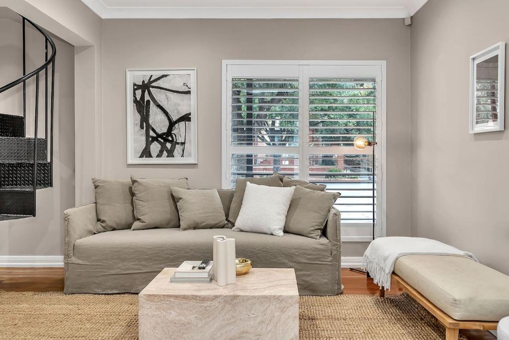 ein Wohnzimmer mit Sofa und Tisch in der Unterkunft 'Parkstone' Modern Elegance near CBD & Zoo in North Adelaide