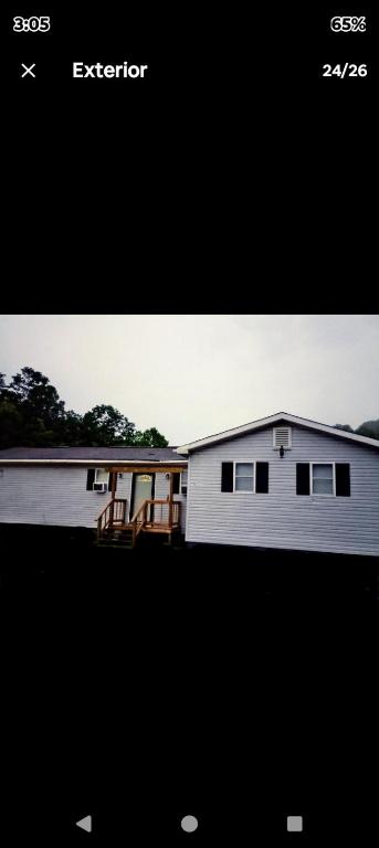a picture of a white house with a house at Sandy's House in Minden