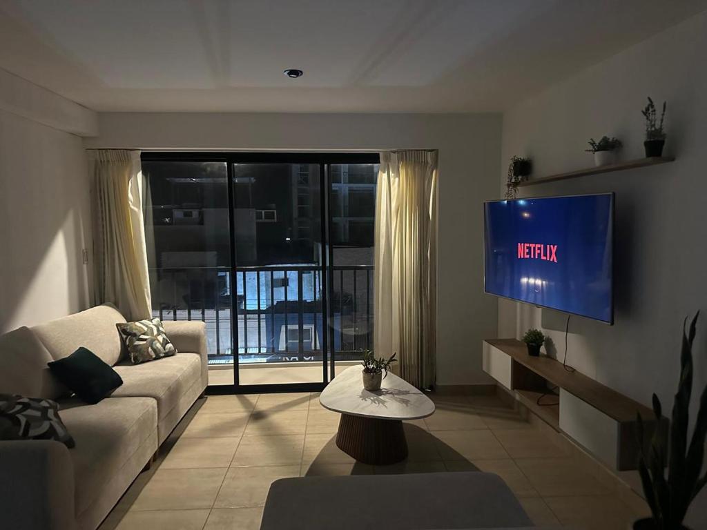 un salon avec un canapé et une télévision dans l'établissement DPTO de 2 Dorm y Terraza Vista al Mar, à Pimentel