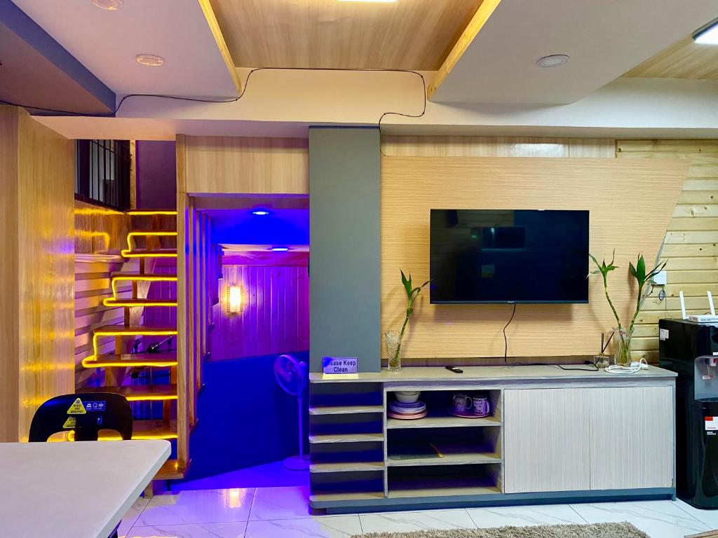 a living room with a flat screen tv on a wall at 3 Bedroom Condotel Ina Mansion Baguio City in Baguio