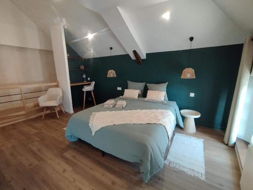 a bedroom with a bed and a green wall at Duplex en bord de Loire in Saint-Martin-de-la-Place
