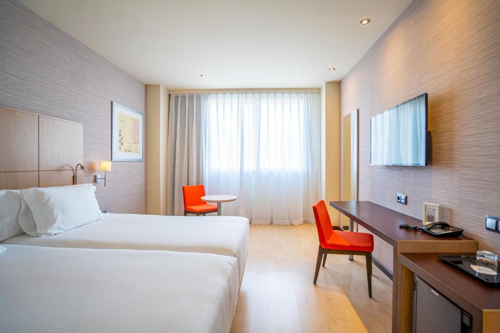 a hotel room with a bed and a desk and chairs at Abba Huesca in Huesca