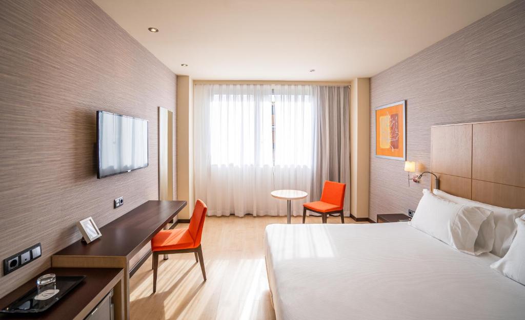 a hotel room with a bed and a desk at Abba Huesca in Huesca