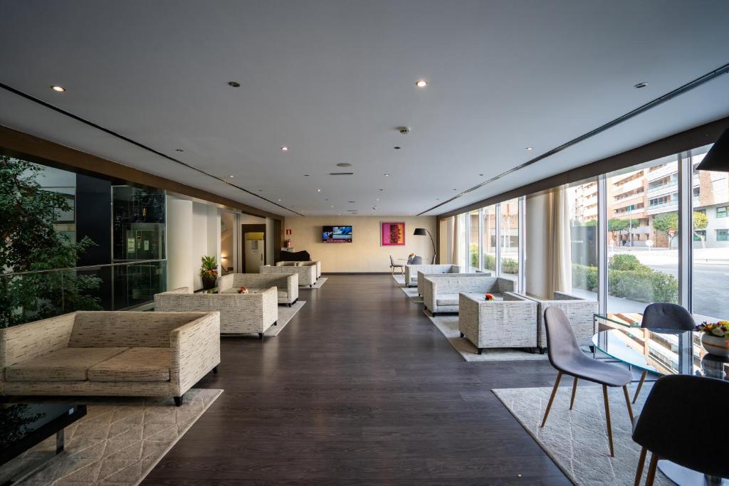 a lobby with couches and chairs in a building at Abba Huesca in Huesca