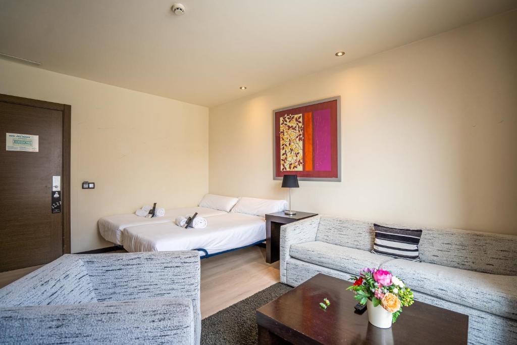 a hotel room with a bed and a couch at Abba Huesca in Huesca