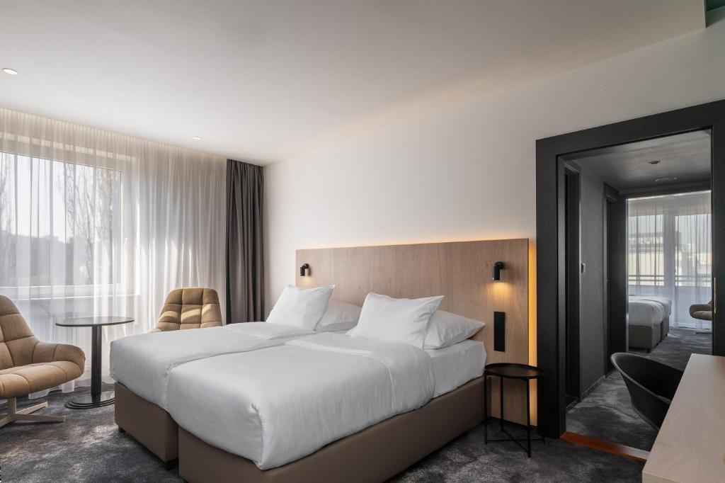 1 dormitorio con 1 cama blanca grande y ventana grande en OREA Congress Hotel Brno, en Brno