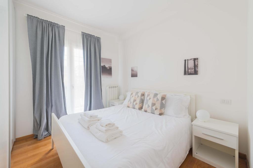 ein weißes Bett mit Handtüchern darauf in einem Schlafzimmer in der Unterkunft LoveRhome Apartment 3 in Rom