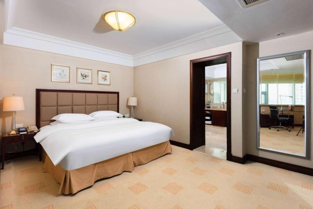 Postel nebo postele na pokoji v ubytování Ramada Plaza Optics Valley Hotel Wuhan (Best of Ramada Worldwide)