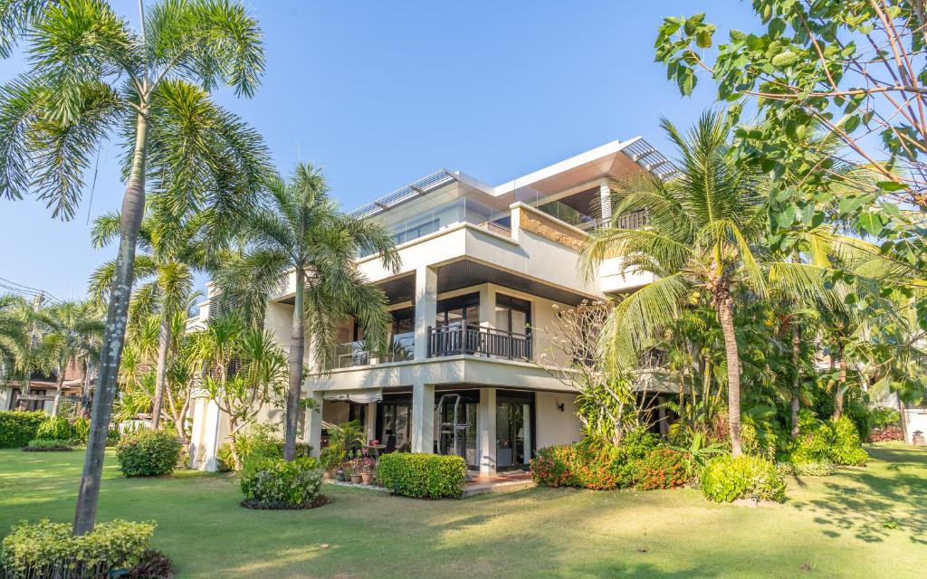 a large house with palm trees in front of it at 3BR Casa Oasis - Beachfront Home in Laguna & Layan Chom Tawan and Maan Tawan Residences in Phuket Town