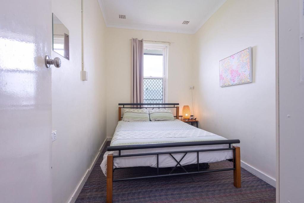 a bedroom with a bed in the corner of a room at 1849 Backpackers Albany in Albany
