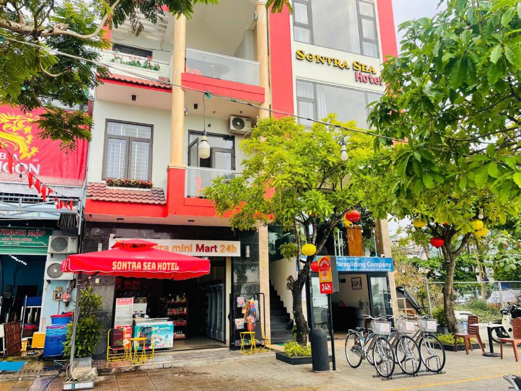 a building with a red umbrella on a city street at Sontra Sea Hotel in Danang