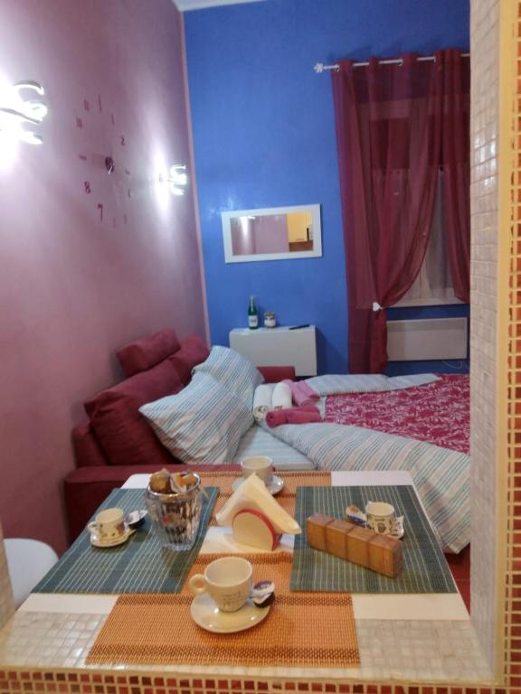 a room with a bed and a table with dishes on it at LA CASA DI CARTA red in Fiuggi