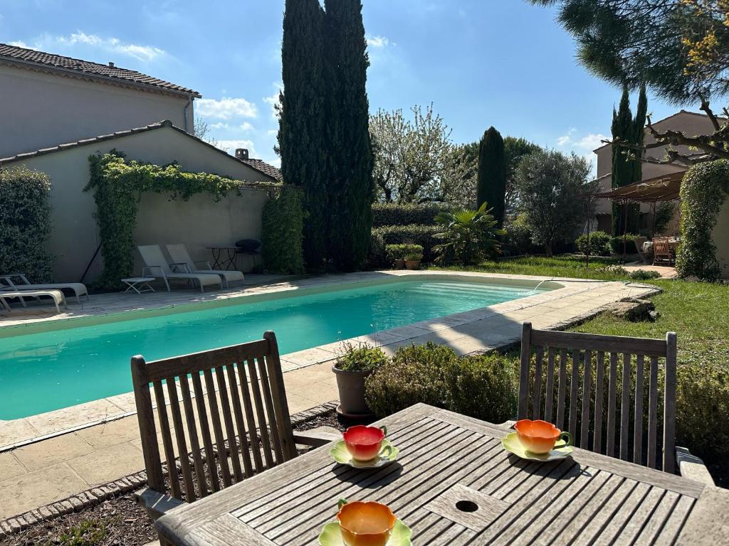 - une table avec des fruits à côté de la piscine dans l'établissement Villa Nicole avec piscine & jardin privés, parking dans le cœur du Luberon, proche Gordes, Roussillon, Goult, Bonnieux, à Oppède