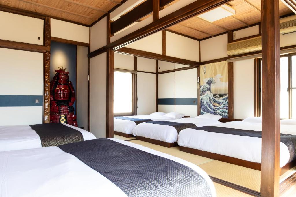 a row of four beds in a room at The Guest House Samurai in Tokyo