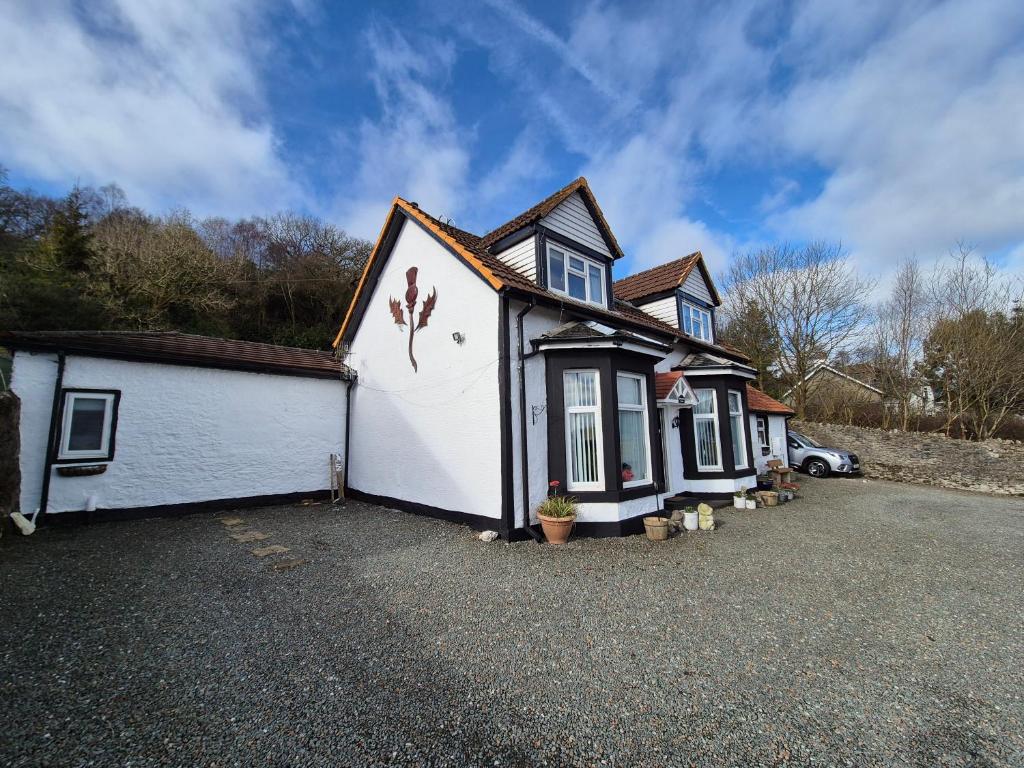 a white and black house with a driveway at Montague Villa in Dunoon