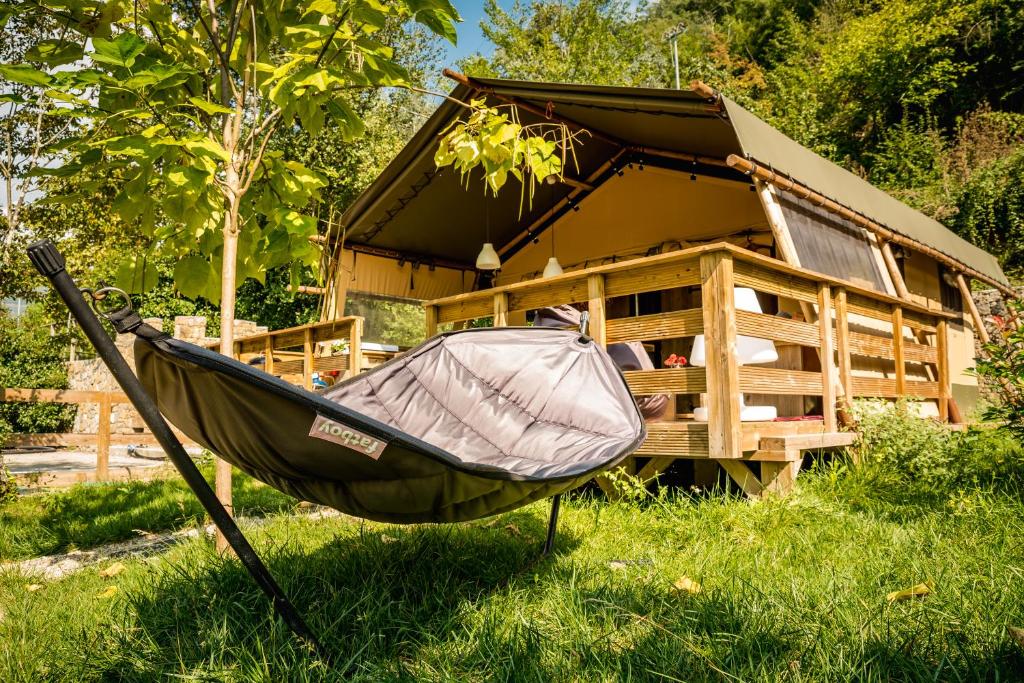 a hammock in the grass in front of a house at Lodge Holidays - Camping Delle Rose in Case Romagnoni