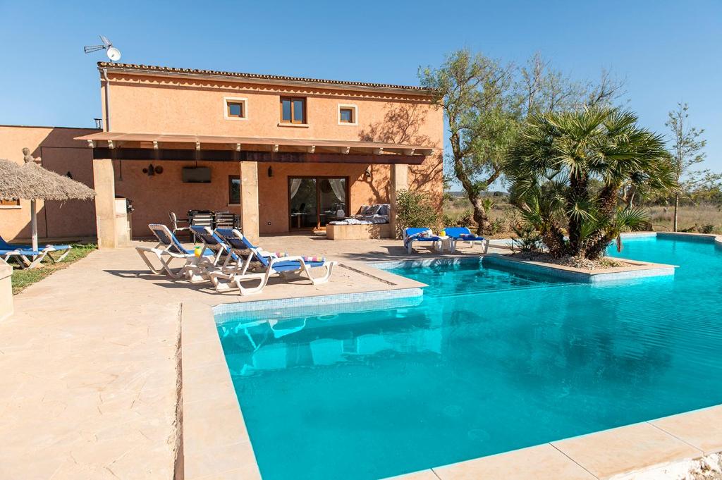 une piscine avec des chaises et une maison dans l'établissement Finca del Corazòn, à Campos
