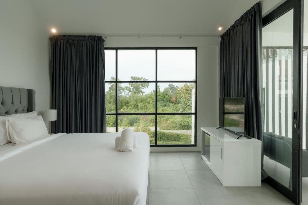 a bedroom with a white bed and a large window at Villa Valeria in Ungasan