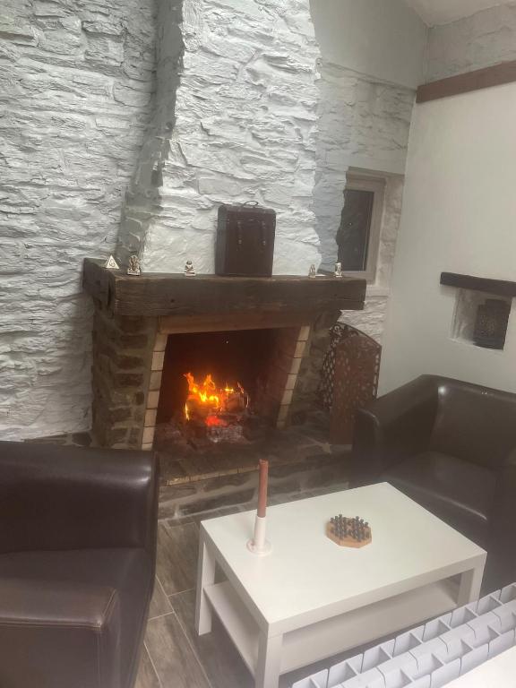 - un salon avec une cheminée, un canapé et une table dans l'établissement Charmante maison de vacances, à Haulmé